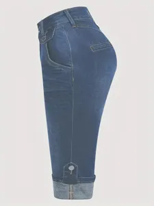 Vue de détail d'un pantalon court en jean bleu foncé pour femme avec revers et boutons élégants.