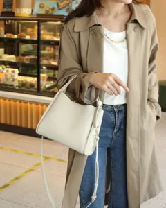 Minimalist genuine leather shoulder bag for women, elegant bucket design with adjustable strap.