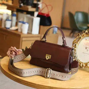 Vintage bruine lederen crossbody tas voor dames, retro handtas met brede geweven riem.