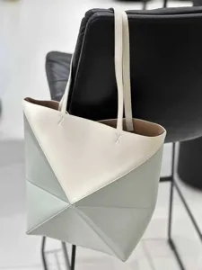 Detailansicht der geometrischen Falt-Tragetasche mit zweifarbigem Design und feinen Doppelriemen.