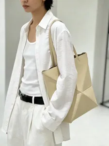 Detailansicht der beigen geometrisch gefalteten Schultertasche aus weichem Kunstleder.