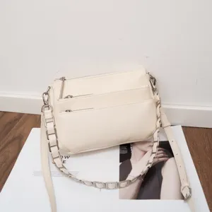 Detailed view of the genuine leather multi-zipper cross-body shoulder bag in soft beige finish.
