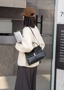 Detailed view of a stylish women's black crocodile pattern leather shoulder handbag.