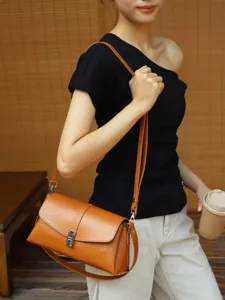 Retro vegetable-tanned leather shoulder bag detail, elegant crossbody envelope design with lock.