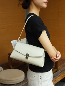 Stylish minimalist women underarm shoulder bag, elegant faux leather envelope purse detail view.