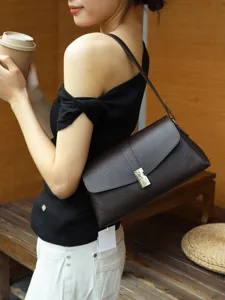Detailed view of the vintage brown underarm envelope shoulder bag with metal lock closure.