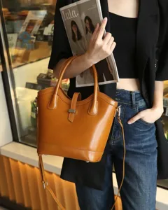 Bolso cubo marrón de cuero genuino para mujer, elegante bolso de hombro bandolera.
