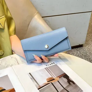 Elegant light blue genuine leather long wallet for women with snap closure and large capacity.
