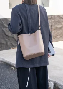 Minimalist leather bucket bag with metal lock detail, perfect for daily autumn commute.