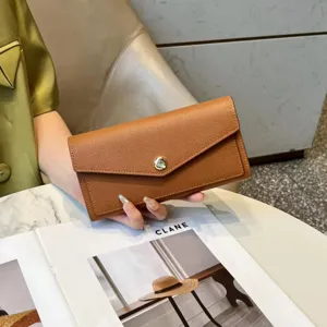 Detail view of a stylish brown leather long wallet for women, elegant envelope design.