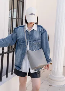 Minimalist grey cross-body bucket bag for women, stylish daily commuter shoulder bag with adjustable strap.