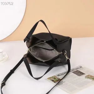 Black leather shoulder bag interior detail showing secure zipper compartment and sturdy straps