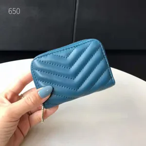 Dettaglio del portacarte in pelle trapuntata blu, piccolo portafoglio con cerniera.