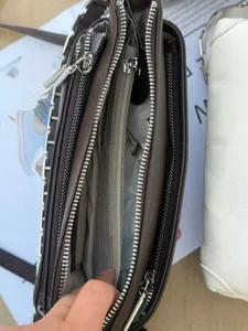 Brown leather multi-zipper shoulder bag interior detail showing compartments and lining.
