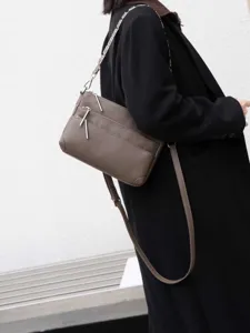 Elegant genuine leather crossbody bag with multiple zippers and stylish chain strap for women.