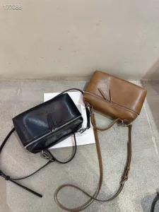 Λεπτομερής εικόνα από κομψές δερμάτινες τσάντες χιαστί σε κλασικό μαύρο και καφέ χρώμα.