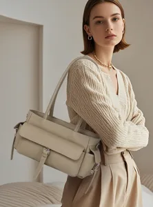 Detailed view of the elegant beige leather shoulder handbag with front flap and buckle.
