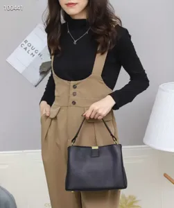 Casual black leather shoulder bag detail shot, soft texture with metal lock, chic daily wear style.