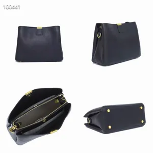 Detail view of black leather crossbody bag featuring gold hardware, zippers, and bottom metal feet.