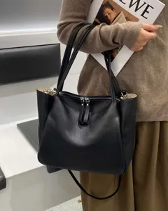 Black soft leather tote bag for women, large capacity commuter shoulder handbag for daily use.