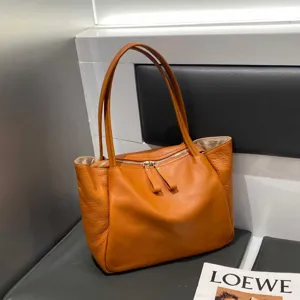 Detailed shot of large soft leather women commuting shoulder tote bag with top zip closure.