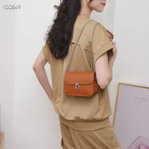 Stylish brown leather crossbody shoulder bag featuring metallic chain and elegant lock clasp.