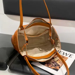 Orange soft leather tote bag interior detail showing spacious main compartment and zip pocket.