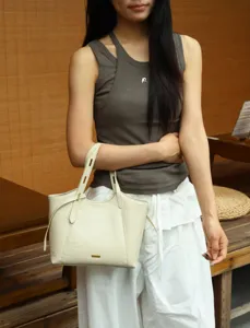 Detail shot of minimalist cream leather tote shoulder bag, versatile everyday underarm bag style.