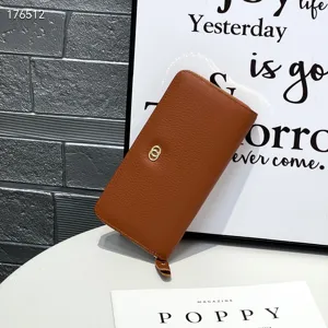 Detail shot of brown genuine leather long wallet with soft texture, zipper closure and metal ring.