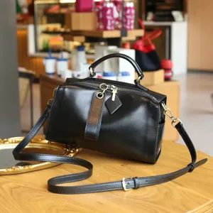 Detail view of black leather boston bag, vintage top layer cowhide crossbody handbag.
