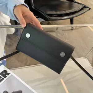 Minimalistische schwarze Lederschultertasche mit Palmstruktur und edlen MetallDruckknöpfen.