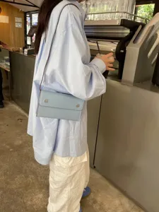 Lässige Umhängetasche aus Leder für Damen, minimalistische hellblaue Handytasche.