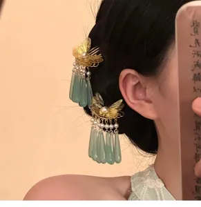 Close-up detail of traditional Chinese gold butterfly hair comb with pearl and jade tassels.