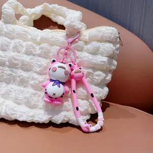 Detailopname van schattige roze kikker cartoon sleutelhanger aan witte handtas hangend.
