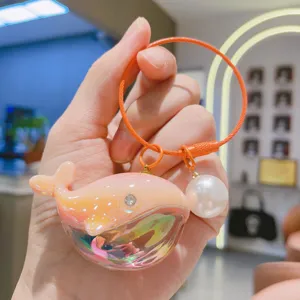 Nahaufnahme des süßen Laser Wal Schlüsselanhängers mit Perlenanhänger und glänzendem Design.
