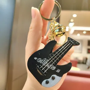 Detailed view of a mini guitar keychain music toy with bell pendant and cute design.