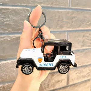 Primer plano del llavero de coche de policía jeep en miniatura, con anillos metálicos y diseño.