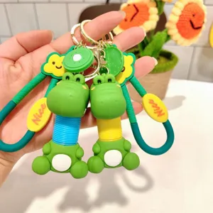 Cute cartoon telescopic dinosaur keychain detail shot, green keyring bag pendant stress relief gift.