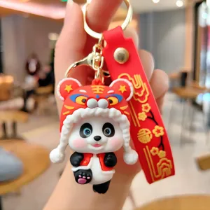 Gros plan détaillé du porte-clés mignon panda avec chapeau de tigre et sangle rouge.