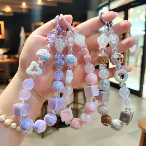 Detailed view of pastel acrylic beaded phone charms and keychains with shiny iridescent finish.