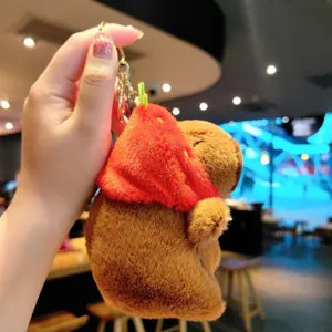 Capybara plush keychain detail view, cute strawberry cape design, soft hanging pendant.