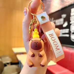 Cute cartoon capybara keychain with little duck pendant and silicone strap detail.