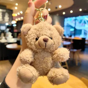 Dettaglio portachiavi orsetto di peluche, soffice pelliccia marrone con anello metallico.