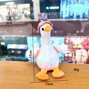 Cute white duck plush toy keychain detail shot, showcasing mini pink hat and backpack design.