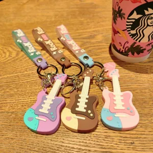 Detailopname van creatieve gitaar PVC sleutelhangers in verschillende kleuren met riempjes.