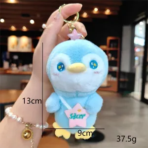 Dettaglio del portachiavi con peluche di pinguino blu carino con morbida consistenza soffice.