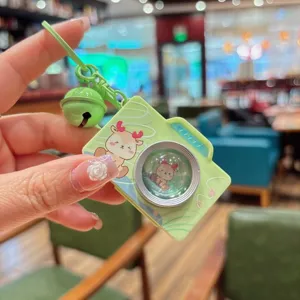 Detailopname van de groen retro camera sleutelhanger met schattig hertontwerp en bel.