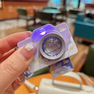 Detailopname van de schattige paarse mini camera sleutelhanger met ledlicht en kattenmotief.