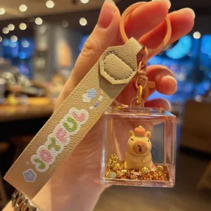 Cute capybara liquid acrylic keychain detail shot, showing glitter quicksand and leather strap.