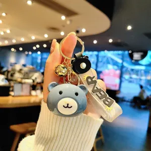 Close-up detail of a cute blue bear acrylic keychain and bag charm with a bear strap.
